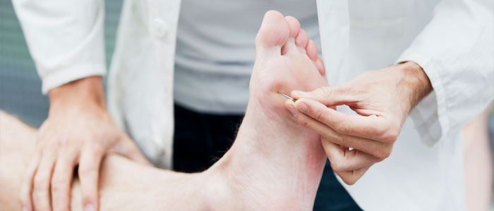 chiropractor checking neuropathy in foot